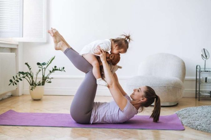 Mère et fille pratiquant le sport à domicile sur un tapis de yoga